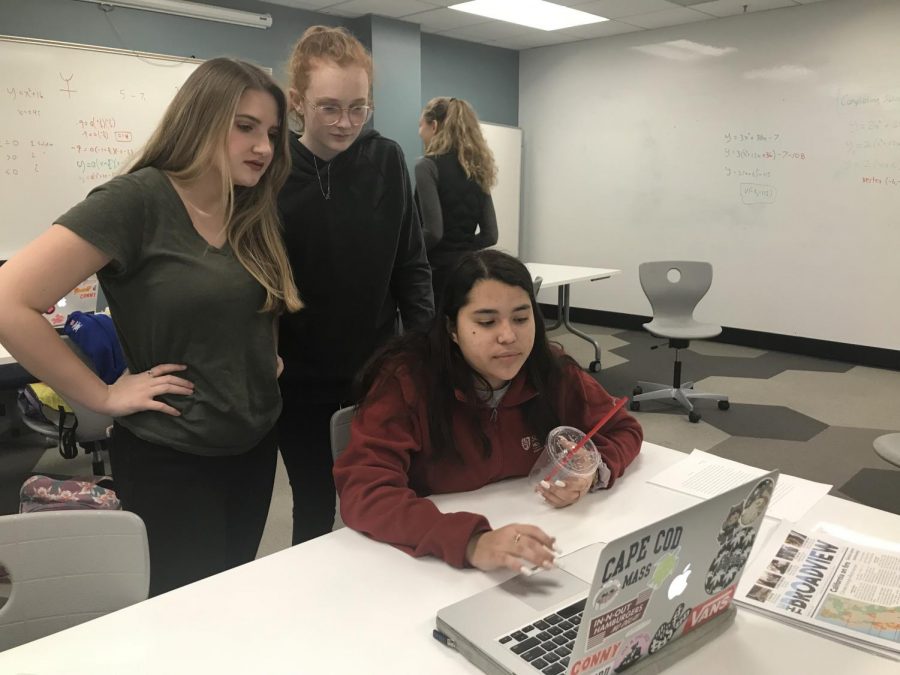 Juniors Margaret Millar, Zoë Forbes and Julianna Ovalle crowd over a computer to see the news about the bomb threats. Students in HL Global Politics discussed the issues in class.