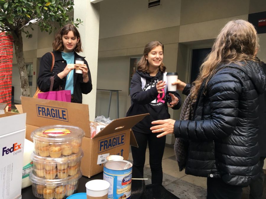 Laurie Pomeranz, the teacher advisor of Knight Light, hands junior Sofia Telfer a hot chocolate before A Period finals. The Knight Light club provided beverages and snacks for students on the Pine-Octavia campus to ease stress before finals. 