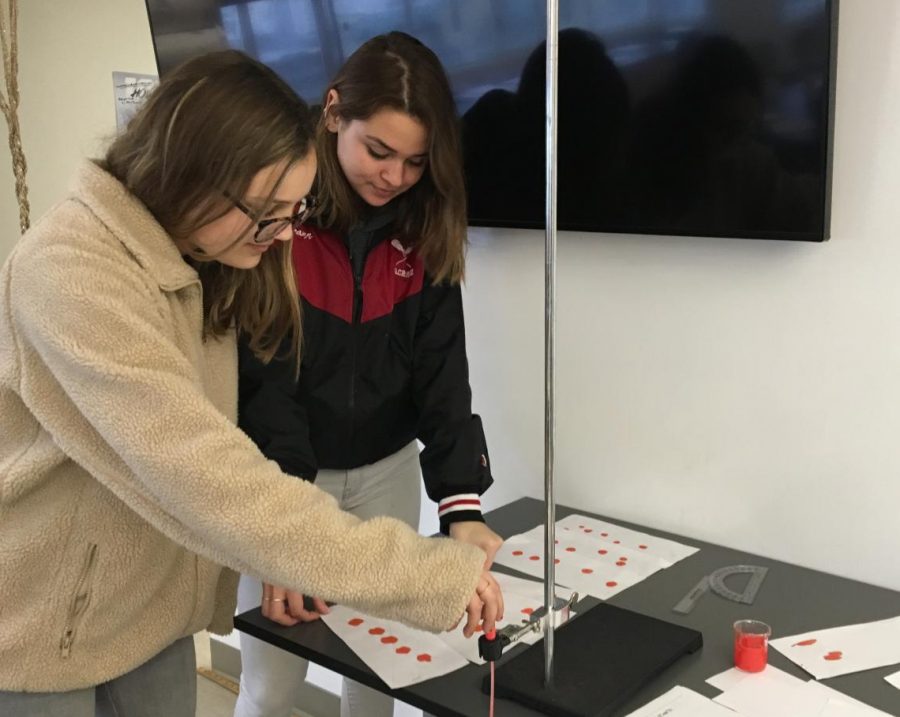 Seniors Rachel Cramer and Sophie Mack complete a blood spatter lab in physics. Students in all sciences completed labs relating to Forensics as part of an IB Science requirement.