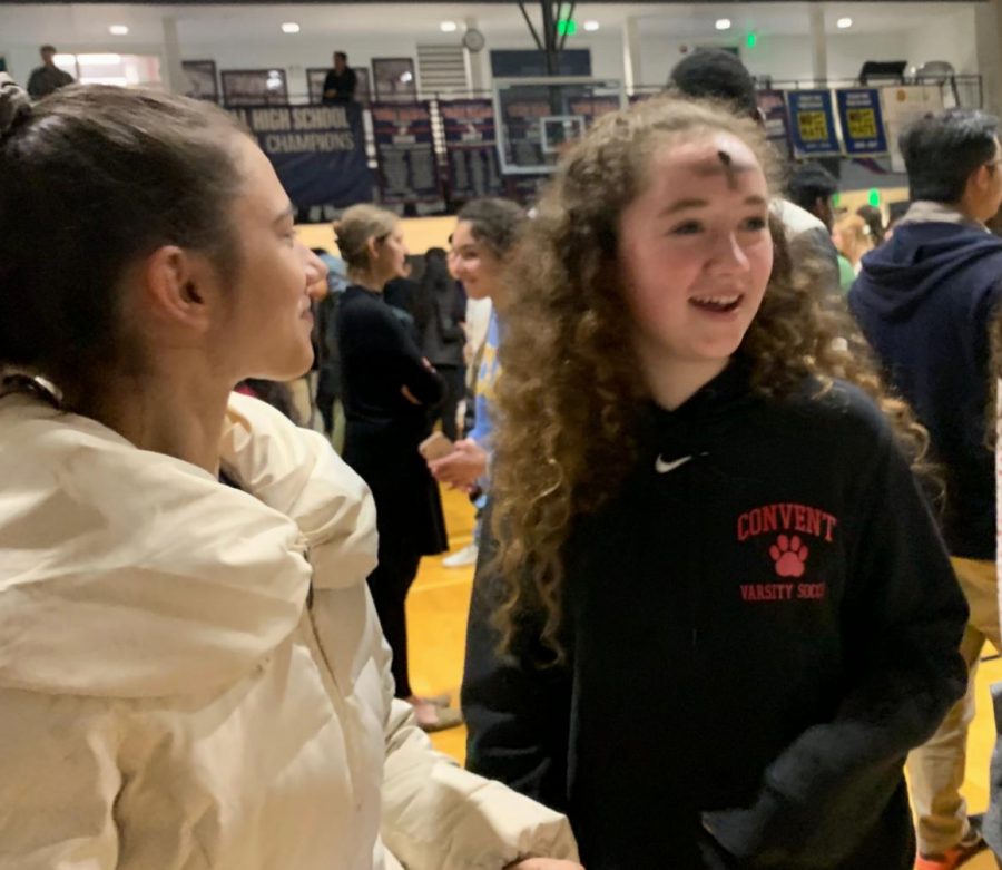 Freshmen Lily Peta and Mackenna Moslander  walk back to their seats after receiving a cross on their foreheads during Ash Wednesday mass. Deacon Eddy blessed the ash before drawing crosses. 