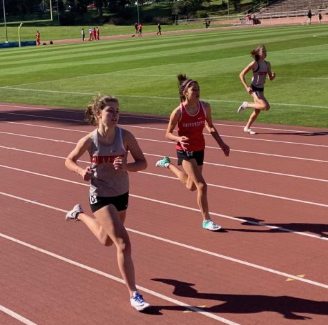 Junior Sofia Telfer and freshman Madeline Thiara run in the girls 400 meter race. Each runner competed in two to three events at the meet.