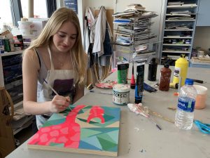 Freshman Madeline Drda paints a giraffe for her spirit animal art project. The class used the project as a way to practice color theory. 