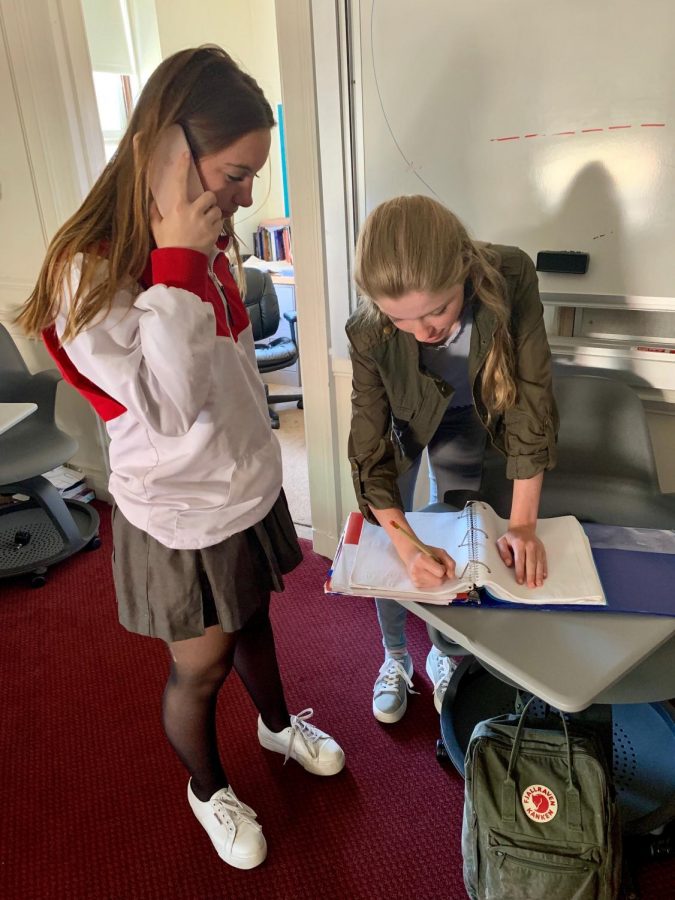 Sophomores Naia Urruty and Olivia Callander take notes while interviewing Jules His, a former exchange student from a Sacred Heart school in Nantes, France. Students were encouraged to speak to foreign exchange students to gain more  personal information about their exchange experiences.