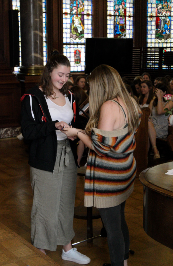 Graduating senior Delaney Tobin presents junior Margaret Millar with her class ring. The Ring Ceremony is a Sacred Heart tradition. 