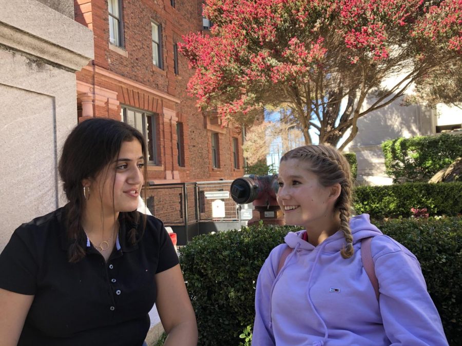 Freshmen Tala El Qadah and Sophie Jones discuss ways to prevent the spread of lice to other grades as they wait for the bus. Both students wore braids to school to protect their hair from further exposure to lice. 