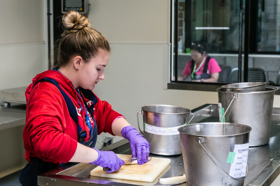 Senior Margaret Millar chops fish while preparing meals for sea lions at the beginning of her
Sunday shift. Millar began volunteering as part of the Youth Crew at TMMC in Feb. 2019.