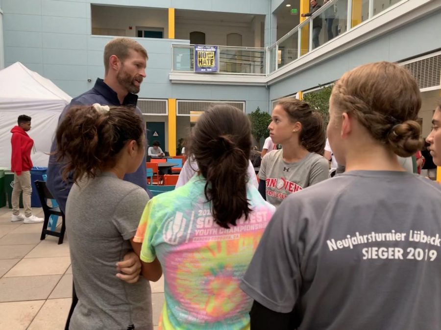 Coach Michael Buckley talks to the varsity girls before Fridays race. The race will be the final meet of the season and the league championship. 