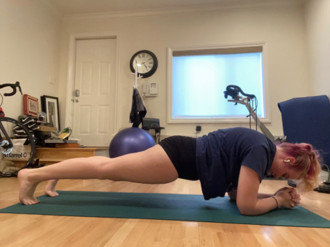 Sophomore Samantha Calvin uses her yoga mat in her room at home while holding a plank position. Calvin says she has practiced yoga every morning since the beginning of virtual learning this year and that she enjoys being able to control her own workouts.