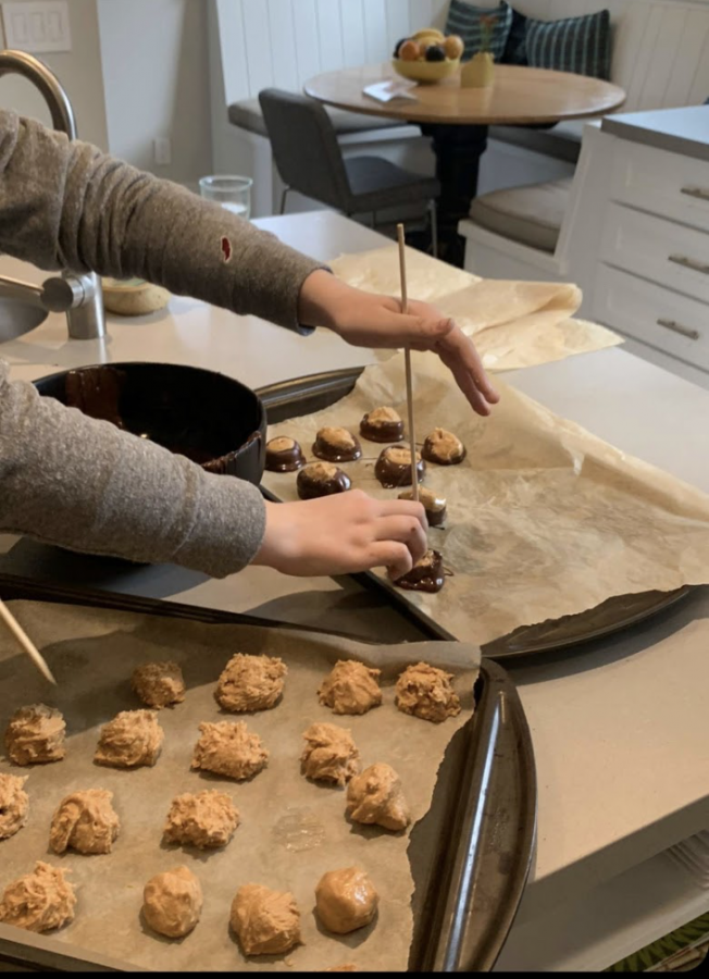 Sophomore Josie Flanagan places chocolate-covered cookies on a cooking sheet. Students were encouraged to submit photos of their “most scrumdiddlyumptious” holiday-themed baked-goods as part of the holiday spirit contest. 