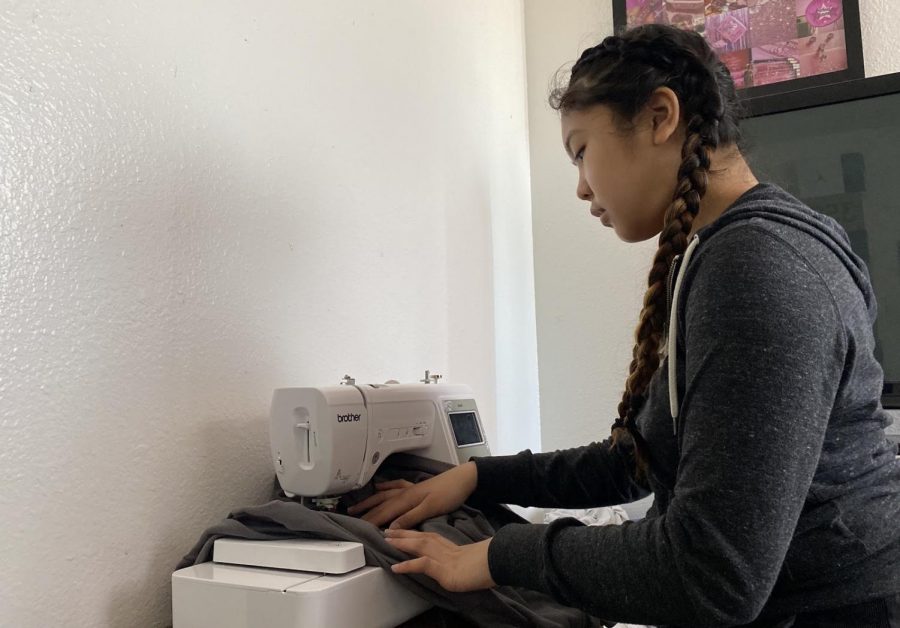 Sophomore Isabella Alarcon, who runs a business reselling her customized clothing, alters a sweatshirt. A 2018 study of 1,000 teens showed that 41% would consider entrepreneurship as a career option versus working in a traditional job, according to Junior Achievement.