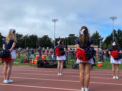 The newly established cheerleading squad roots on the football team during Saturday’s game. The Knights lost 22-20 to Woodside Priory School.