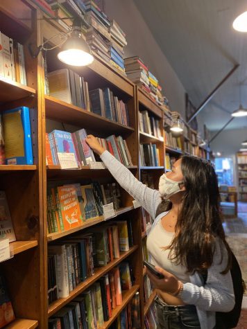 Senior Mira Chawla browses the shelves of Browser Books on Fillmore Street. The store is one of three locations owned by Green Apple Books, who have once again opened their doors to the community for literary events and shopping.