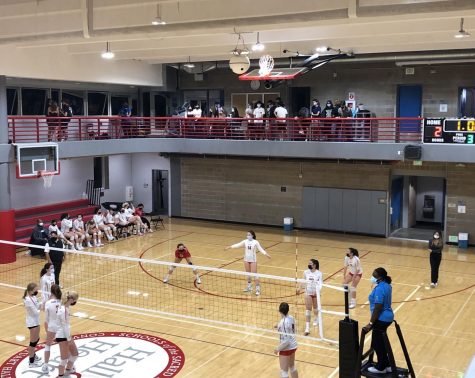 Student spectators cheer on the varsity volleyball team as they enter the third set of the match. The Athletics Department has permitted student attendance of all volleyball home games.