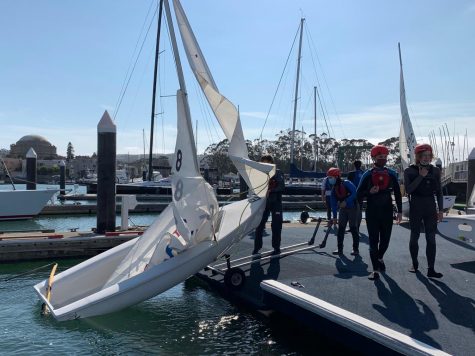 Sophomore Natalie Tonkovich and senior Sebastian Green launch Boat 8 at the St. Francis Yacht Club on Sept. 8. Sailors returned to practice twice a week this fall season.