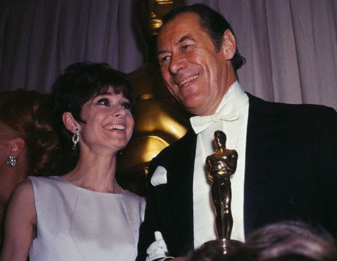 Audrey Hepburn with Rex Harrison holding an Academy Award. This photo was from the 37th Academy Awards in 1964. 