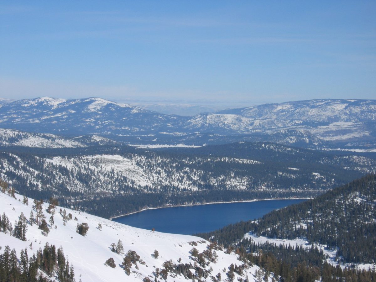 Photo of Lake Tahoe during winter with snow covered mountains. Palisades Tahoe has had two avalanches in two days this year.