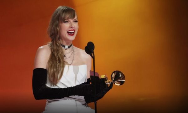 Taylor Swift on the Grammys stage accepting her award for Album of the Year. She has won this award four times, with a total of 14 Grammy awards to her name. 