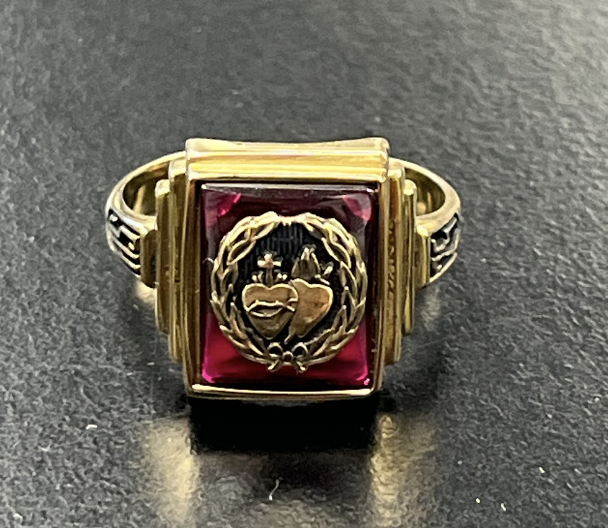 A ring purchased by a junior, and it was handed to them at the Chapel by a senior. Juniors could pick between a gold or silver setting, and a red, blue, or black stone. 