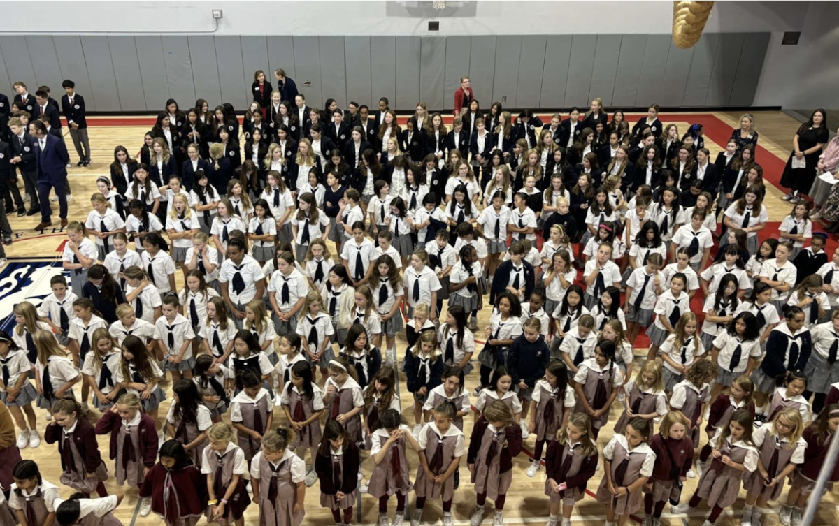 Convent elementary students stand together to sing at Mass. Third grade was seated in the front, while eighth grade was in the back.