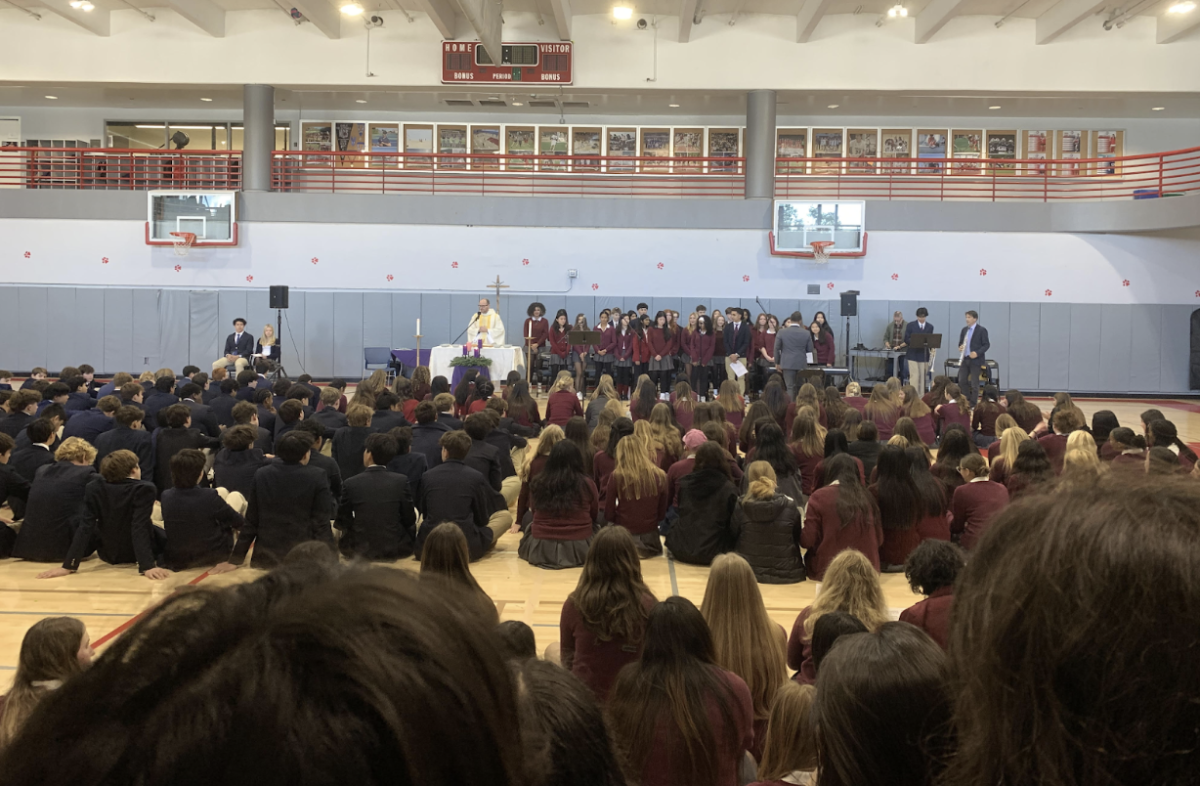 Students adorned in dress uniform participate in the mass of the immaculate conception in the Siboni gym. All grades and faculty are present for this significant event. 