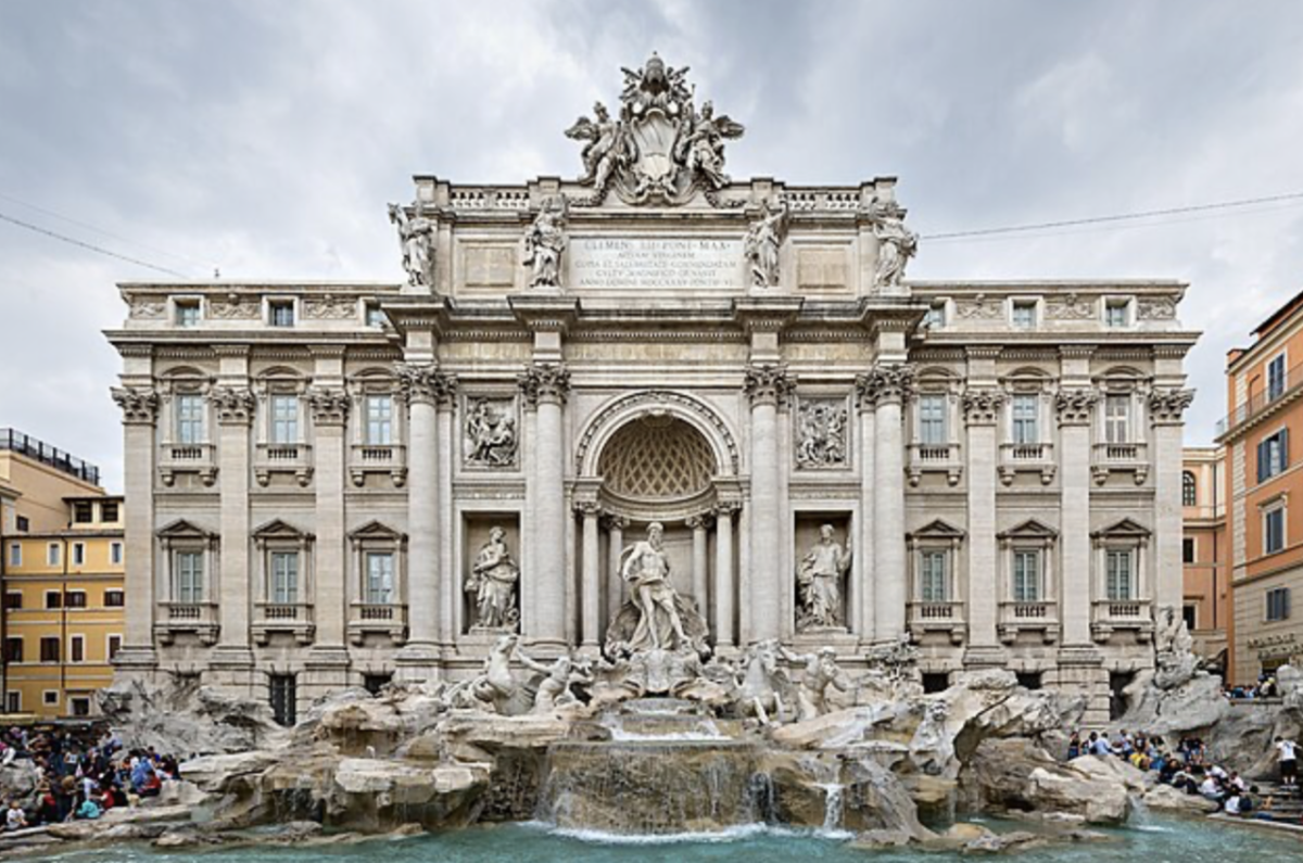 The Trevi Fountain, backed by the iconic Palazzo Poli, is a central attraction in Rome, Italy. The statues carved into the fountain depict a scene where the sea god, Oceanus, is taming water.